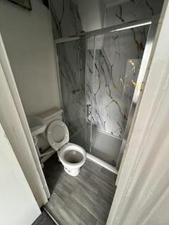 A compact bathroom featuring a modern framed gl...