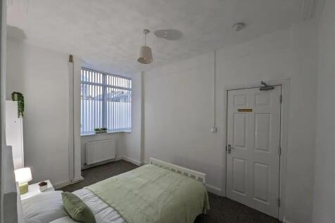 A bright, tidy bedroom featuring a single bed w...