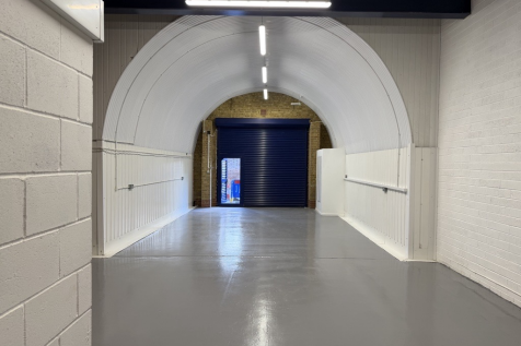 An empty arch with lining and a WC cubicle to the back