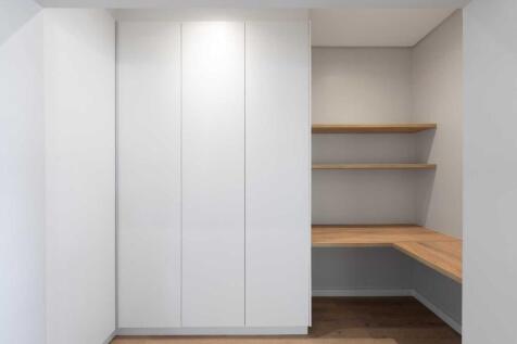Second bedroom with open plan built in cupboards and shelves