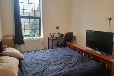 Bright double bedroom with a large window, comf...