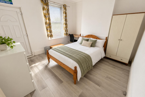 Bright bedroom with sage bedding and greenery-5.pn