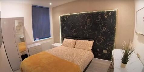 Cosy double bedroom with feature headboard and ...