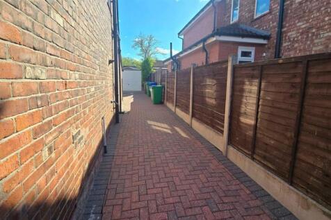 Clean paved side access path with sturdy fencin...