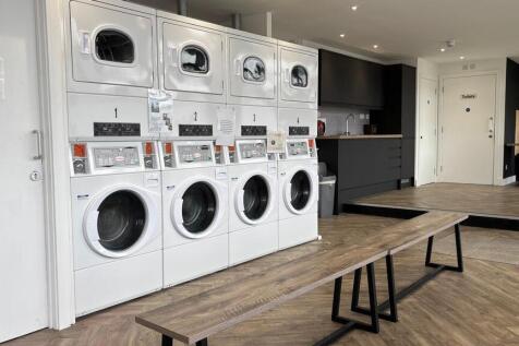 Modern laundry facility with stacked washers...