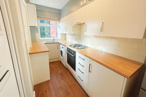Bright, modern galley kitchen with wood-effect ...