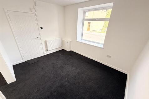 Bright bedroom with plush carpet and large wind...