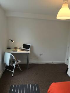 Bright, simply furnished bedroom corner with a ...