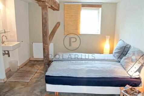 A cozy bedroom with a double bed, soft lighting, a