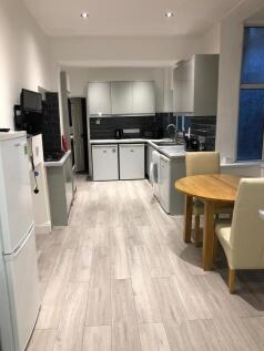 Bright, modern galley kitchen with pale wood-ef...