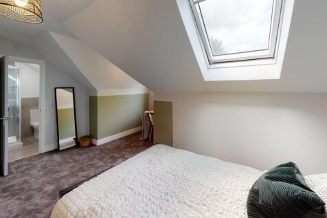 A cozy bedroom with a skylight providing abunda...