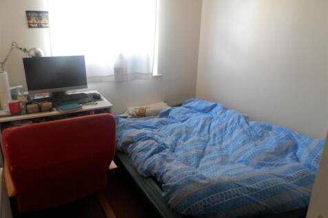 Bright, simply furnished bedroom with a double ...