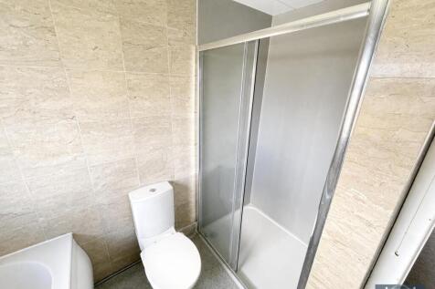 Modern tiled bathroom with shower stall and bat...