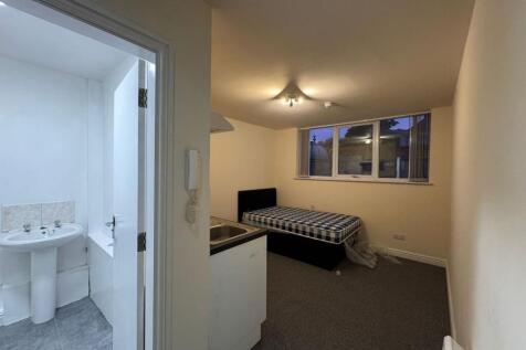 A cozy bedroom featuring a large window allowin...
