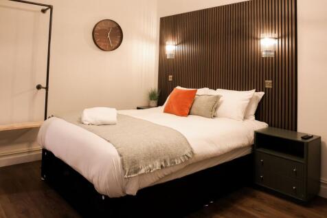 Stylish double bedroom with feature wood paneli...
