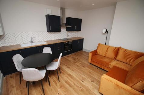 Modern open plan kitchen with vibrant sofa area...