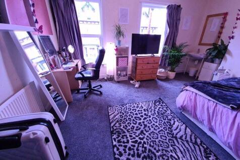 A spacious and well-lit master bedroom featurin...