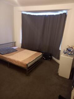 A modest bedroom with a single bed, a small whi...