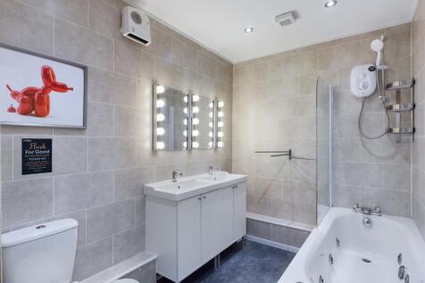 A spacious and modern bathroom featuring a rela...