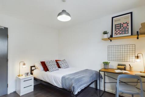 A modern and tidy bedroom featuring a comfortab...