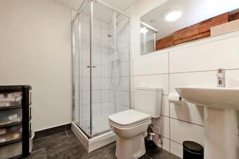 Bright, modern bathroom with a corner glass sho...