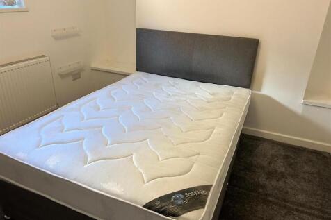 Neat double bedroom with a modern upholstered b...
