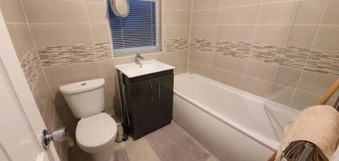 Modern tiled bathroom with bath and vanity...