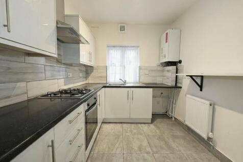 Modern galley kitchen with white cabinetry, int...