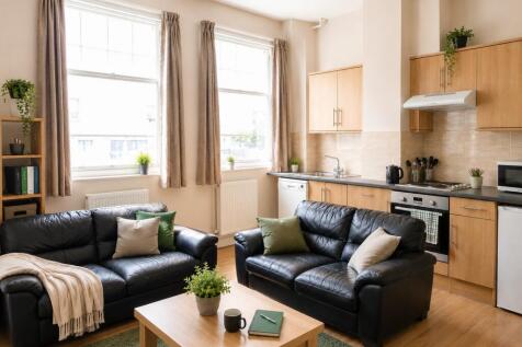 Bright open-plan lounge with plush leather sofa...