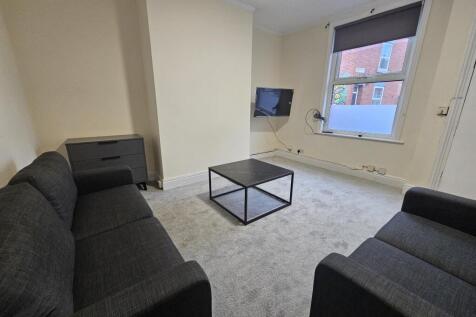 Bright communal lounge with matching sofas, cen...