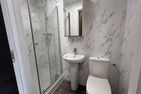 A modern bathroom featuring a spacious shower e...