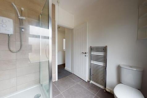 Modern bathroom with walk-in shower, chrome hea...