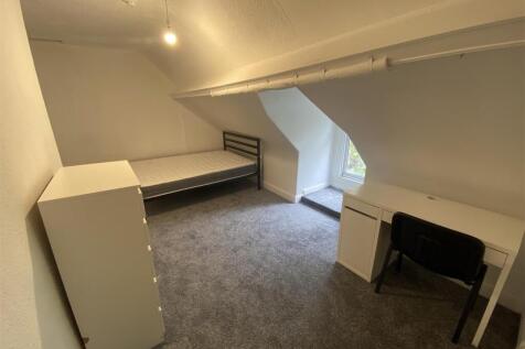Bright attic room with desk and plush carpet...