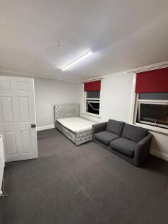 Expansive bedroom with plush bed and sofa area...