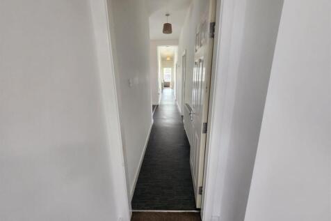 Bright, clean hallway with neutral white walls ...