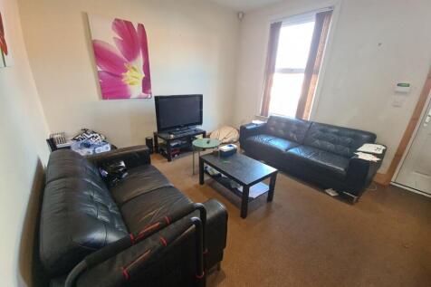 A welcoming, well-lit living room featuring a c...