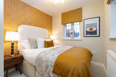 A cozy bedroom features a plush bed with a mustard throw in the foreground