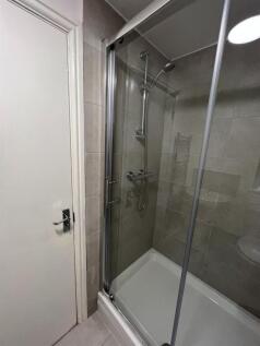 Modern bathroom featuring a fully enclosed glas...