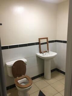 Simple tiled bathroom with pedestal sink and to...