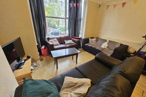 A spacious and well-lit living room featuring a...