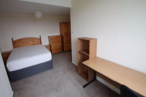 A tidy and functional bedroom featuring a comfo...