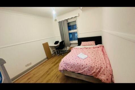 Bright bedroom with wooden floors and study des...