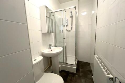 Bright modern shower room with sleek white tili...