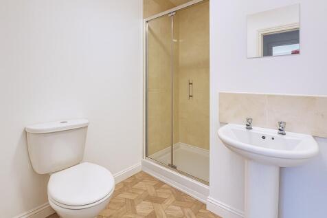 Bright, modern bathroom with a tiled shower enc...