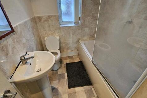 Bright bathroom with bath and neutral tiling...