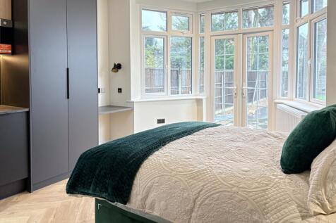 Bright double bedroom with a plush bed, large b...