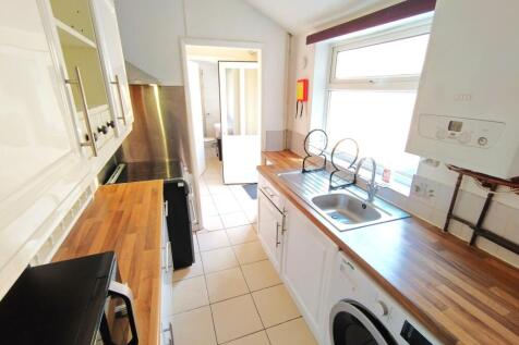 Bright, modern galley kitchen with wooden count...