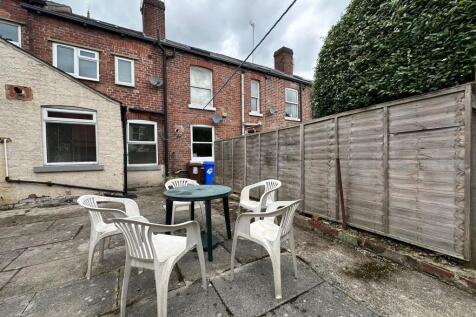 Paved private rear garden with a circular table...