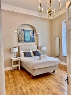 Bright, stylish double bedroom with wooden floo...