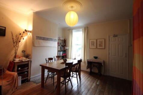 A well-lit, spacious living room with a cozy at...